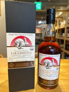 Bottle of Takashimaya Single Malt Japanese Whisky beside its black box label featuring a white rabbit against a red circle and text including Single Malt Japanese Whisky and Takashimaya Buyers Selection