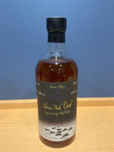 Bottle of Ichiros Malt Card Japanese single malt whiskey on a wooden surface close up of cap and label