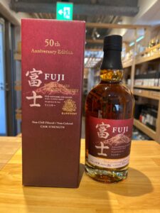 tnhBW1evFpjHoPXGlA8iJpuklwPrs2TASfNneeU4 横浜と東京のお酒買取専門店LIQUORJOYリカージョイ Bottle of Fuji 50th Anniversary Edition single grain Japanese whisky beside its red box on a wooden table