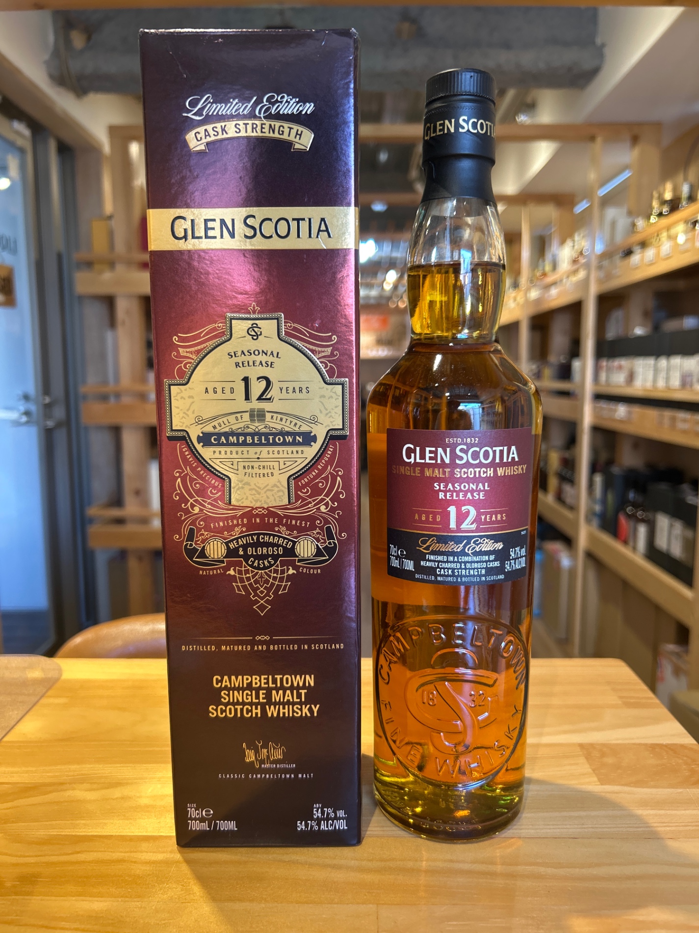 Glen Scotia limited edition cask strength whisky box beside a Glen Scotia bottle on a wooden table in a store.