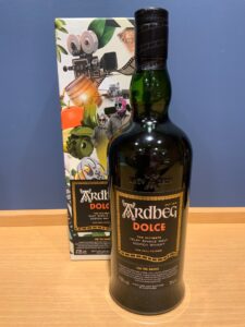 K5LsfyuORTXvJim4fe6XSxPu8mHIKZu2OuMBZc2j 横浜と東京のお酒買取専門店LIQUORJOYリカージョイ Bottle of Ardbeg Dolce Islay single malt whisky in front of its colorful packaging box on a wooden surface