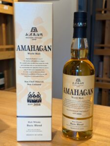 AmaHagan World Malt whisky bottle beside its matching box on a wooden surface