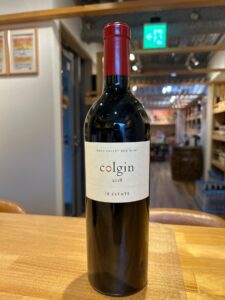 Bottle of Colgin IX Estate 2018 Napa Valley red wine on a wooden counter