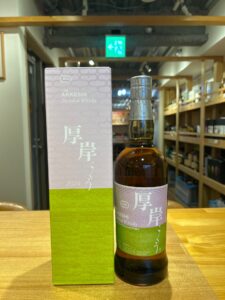 3zTHDJxEfIo9e5XTJvPBysZKVbFLv28wafQppYg5 横浜と東京のお酒買取専門店LIQUORJOYリカージョイ Whiskey bottle beside a lavender box labeled The Akkeshi Blended Whisky and 2024 placed on a wooden table in a liquor store