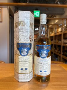 Two bottle and matching box of Provenance single malt Scotch whisky on a wooden table featuring blue labels and a wintry scene