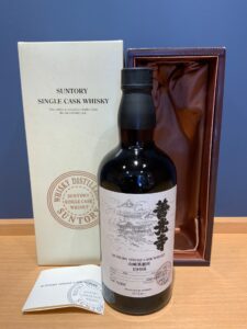 Bottle of Suntory single cask whisky with white box and open burgundy presentation case behind, label showing 1998 release and Japanese text.