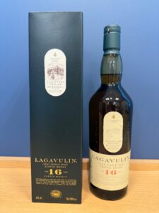 Lagavulin 16 year old Islay single malt whisky bottle beside its dark box on a wooden surface