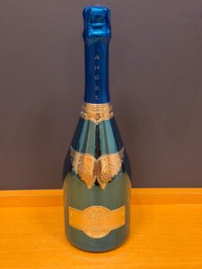 qD5EAhAJfMZyCozS7JNmY8EqS3Gk9PCDRD9XI5kV お酒買取専門店LIQUORJOYリカージョイ Blue foil wrapped champagne bottle with a gold crest label on a wooden table neck visible and standing upright