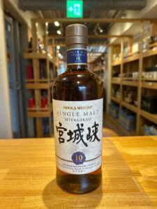 tyS59dLKmBenfUNHwzVyZQJQ01jwr7lSHFZVluIn お酒買取専門店LIQUORJOYリカージョイ Bottle of Nikka Whisky Single Malt Miyagikyo 10 years old on a wooden table in a liquor store with shelves in the background front and center