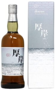 Bottle of The Akkeshi Blended Whisky with a Japanese label beside a tall silver-and-white box; amber whisky in the bottle.