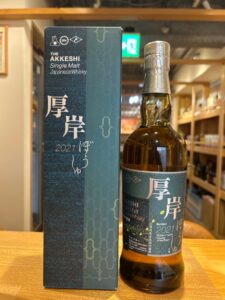 Box and bottle of The Akkeshi Single Malt Japanese Whisky, 2021 edition, blue label and patterned packaging on a wooden surface