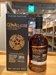 Bottle of The GlenAllachie 2014 Speyside single malt whisky beside its black box with a gold tree emblem and copper label details