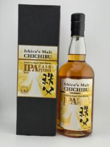 Bottle of Ichiros Malt CHICHIBU Japanese single malt whisky beside its black box Amber whisky visible through clear glass foil seal intact