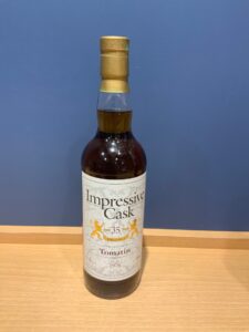 MRr9ZeMzZAFKSQMFNavvWlAopt2pWM7Z8uuiG3ml お酒買取専門店LIQUORJOYリカージョイ Whisky bottle on a wooden table against a blue wall label reads Impressive Cask and Tomatin 35 years