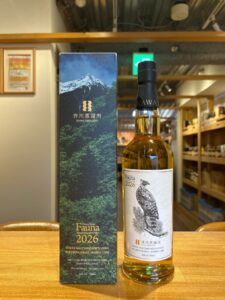 Bottle of Ikawa Distillery Fauna 2026 Japanese whisky next to a tall forest themed box on a wooden counter