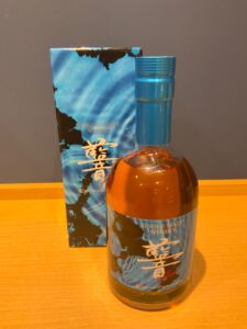 Blue boxed single malt whisky bottle with a matching blue cap on a wooden surface