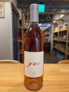 1 お酒買取専門店LIQUORJOYリカージョイ A bottle of rosé wine on a wooden table in a shop label reads gaï and 2016 Napa Valley rosé wine estate bottled