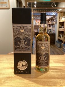 Bottle of Kyoto Fine Whisky and Spirits single malt scotch next to its ornate black and gold box on a wooden counter