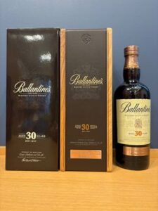 1 お酒買取専門店LIQUORJOYリカージョイ Three Ballantines 30 year old blended Scotch whisky items a black box a dark brown box and a bottle labeled Ballantines 30 Years on a wooden surface