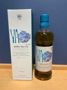 Box and bottle of MARS The YA blended malt whisky with a blue cap white label and blue artwork against a blue background front view displayed on a wooden surface