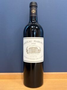 sm お酒買取専門店LIQUORJOYリカージョイ Wine bottle labeled Château Margaux 2023 on a wooden surface against a blue wall